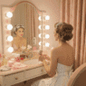 a woman circa 1950 sitting at her vanity and putting in hot rollers