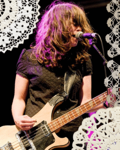 An image of Julie Doiron performing with Eric's Trip with doilies collaged around the edges