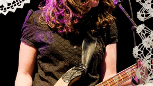 An image of Julie Doiron performing with Eric's Trip with doilies collaged around the edges